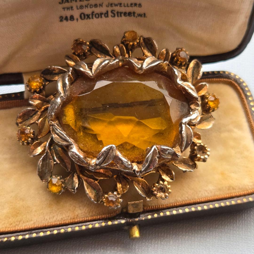 英国ヴィンテージ アンバーカラーの大粒ガラス ブローチ 琥珀色 彫金